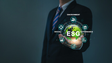 ESG for Environment Social Governance to sustainable development in business and ecology concept. Businessman holding green globe surrounded by icons. Environmental Green business, carbon footprint.