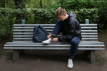 Fototapeta premium A teenage boy ties his shoelaces.