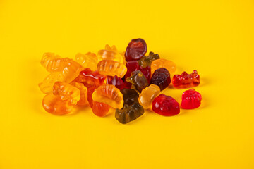 Fruit flavored worm shape, jelly candies. Isolated on yellow background.