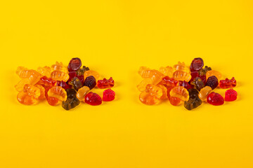 Fruit flavored worm shape, jelly candies. Isolated on yellow background.