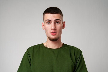 Young Man Looking Surprised Against a Gray Background