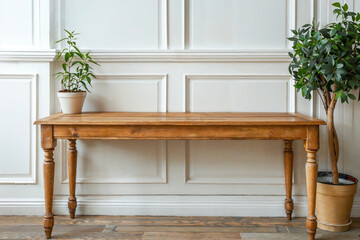 Fototapeta premium Empty wooden table standing in front of white wall with plants background