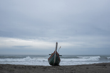 A view of a traditional Indonesian fishing boat being pulled up onto the beach