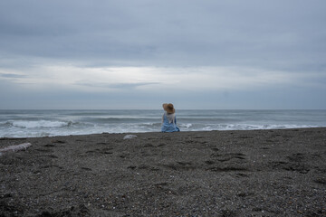 A woman sits alone and enjoys the view of the beach