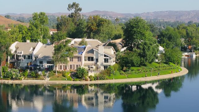 In the morning, runners enjoy a scenic jog around the serene lake in Calabasas, California, USA, surrounded by picturesque landscape and beautiful greenery