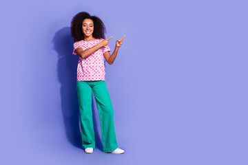 Photo of adorable cheerful woman wear stylish clothes introduce banner empty space isolated on purple color background