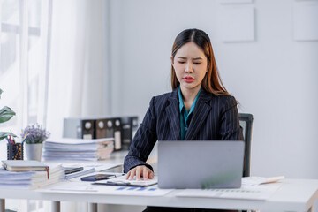 Portrait of tired  business asian woman sitting at a work. documents tax laptop computer in office. Sad, unhappy, Worried, Depression, or overworked, failure employee life stress concept	