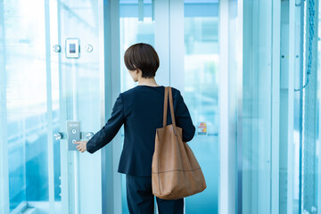 エレベーターのボタンを押す女性 © ponta1414