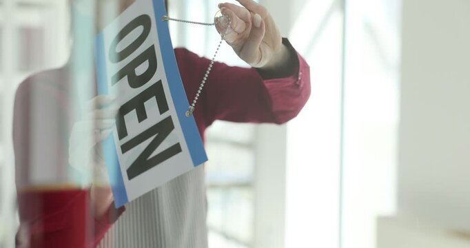 Waitress flips sign hanging on door to signal end of workday