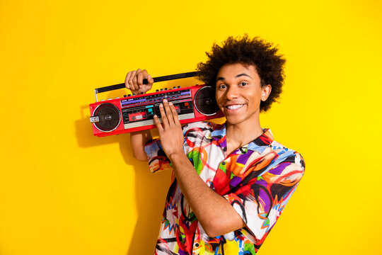 Photo of nice funky young man carry boombox wear shirt isolated on bright yellow color background - Powered by Adobe