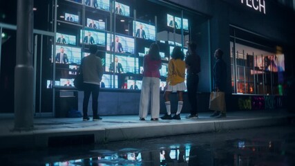 Diverse Group of People Gathered at Night in Front of a Storefront TV Display that is Streaming Evening News Broadcast Channel. Vibrant City Street Reflecting on the Wet Pavement After Rain
