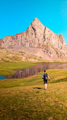 Young adventurer climbing Arroyetas Peak in the Pyrenees, with stunning views of the Ibón de...