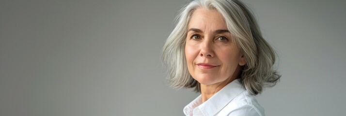 The woman in the picture exudes sophistication and confidence with her stylish grey hair, epitomizing timeless elegance beauty with grace and refinement. Face skin care for rejuvenation and anti-aging
