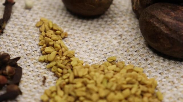 Colorful whole spices and herbs for cooking with rotation teble, Jaiphal, Star Anise, Cardamom, Elaichi, cinnamon, cloves, methi , black and white pepper background rotating display footage. 4k. 