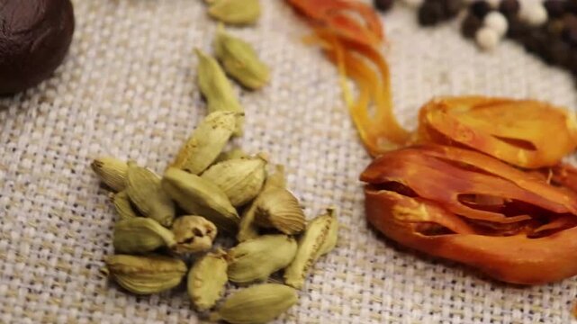 Group of indian curry spices and herbs rotation on Wooden teble one by one. Spices like cardamom, Jhaifal, star anise, Javitri, cinnamon, cloves, methi , black and white pepper  display. 