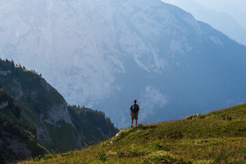 Man, tourist with backpack standing above mountain valley. Loser, Austria alps