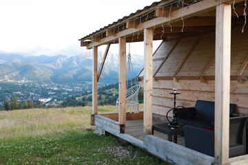 Wooden gazebo with hanging cocoon swing overlooking the mountains. Relaxation area with views of high mountains. Hookah in the mountains.