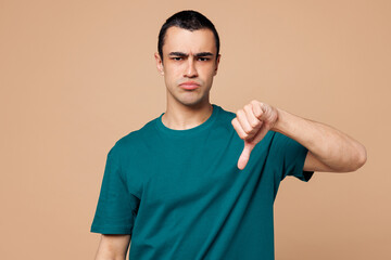 Young dissatisfied displeased sad middle eastern man wear blue t-shirt casual clothes show thumb...
