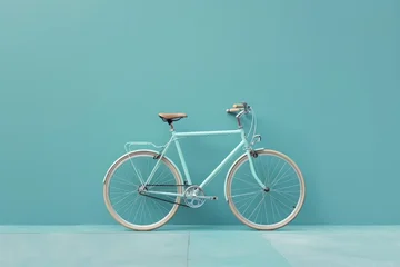 Light blue vintage bicycle is leaning against a light blue wall in a minimalist style setting
