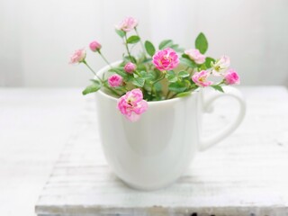 白いカップにピンクのミニ薔薇
