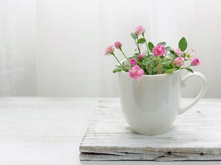 白いカップにピンクのミニ薔薇