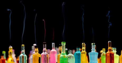 smoke coming out of miniature drink bottles on dark background