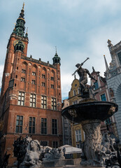 moody shot of the neptune fountain with the town hall in the background in ulica dluga in Gdansk