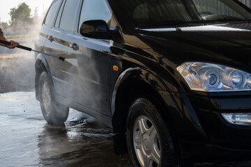 Car washing with foam and water. Washing a car with high pressure water at a professional car wash