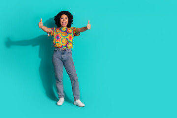Photo of adorable pretty nice woman wear trendy print clothes demonstrate thumb up empty space isolated on cyan color background
