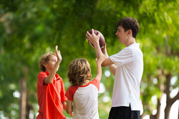 Family playing American football. Kids play rugby