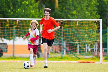 Child playing football. Kids play soccer.