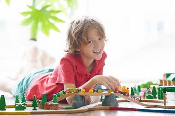 Kids play wooden railway. Child with toy train.