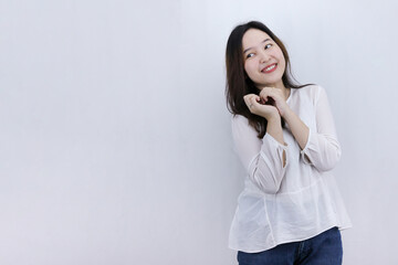 smiling young Asian woman looking away wants something, looking with desire and temptation, standing on white background