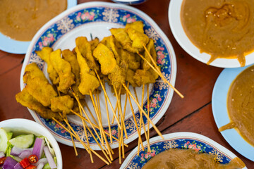 Pork satay marinated in milk on skewers eating with peanut sauce and pickles, sold in restaurants.
