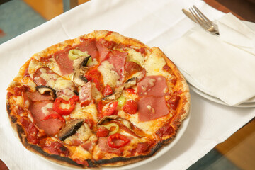 Small size pizza served on the tray on the table in the apartment, comfort food, cozy dining at home