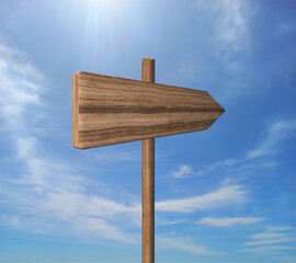 Blank road signpost against blue sky with clouds. Old Empty wooden road sign, arrows, choice and directions signs. Signpost Showing Information. Wooden pointer. Guide sign. 