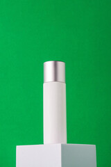 White sunscreen bottle on green background. Sunscreen concept. Skin care concept. Copy space.