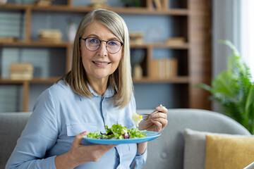 Senior woman eating fresh salad while smiling. Promotes health and well-being with focus on healthy...
