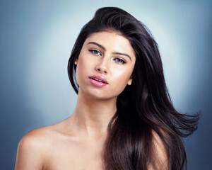 Fototapeta premium Hair, salon and portrait of woman on blue background for haircare, healthy texture and growth. Beauty, confidence and person with cosmetics for keratin treatment, wellness and shampoo in studio