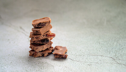 Stack of chocolate slices with raisins on a wooden table.