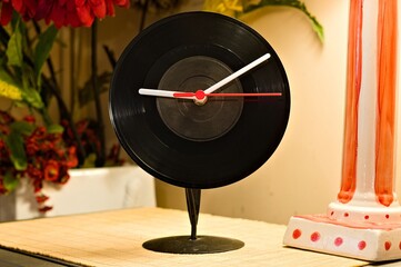 a vinyl record clock on a stand in the home