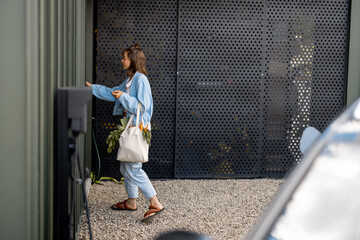 Woman walks with a shopping bag full of fresh vegetables near entrance of a modern house. Concept of healthy lifestyle and modern living