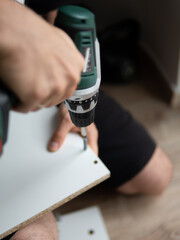 Furniture Assembly Manual. Workman Reading Instruction Installing Cabinet Making House Renovation Indoors.