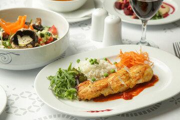 Pan fried chicken fillet served in tomato sauce with rice and fresh vegetables