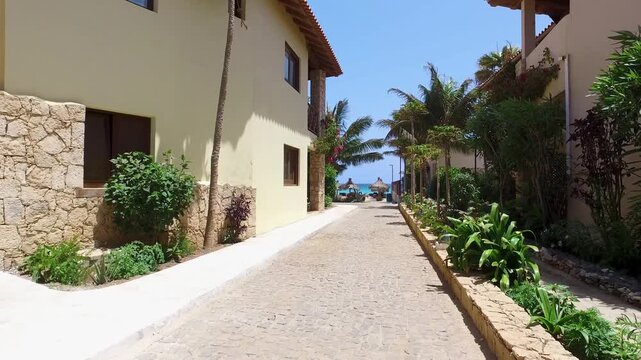 Footage of the beautiful street leading on the beach in Sal Cape Verde Cabo Verde in the summer time showing the romantic relaxing beach front and houses close by on a sunny day in the summer time