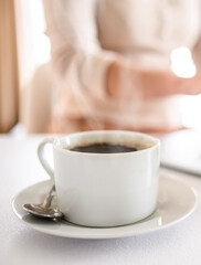 Cup of fresh aromatic hot coffee on a working table. Morning coffee in the office.