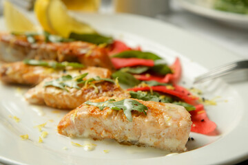Grilled Salmon fillet with marinated vegetables served on the restaurant table