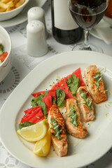 Grilled Salmon fillet with marinated vegetables served on the restaurant table