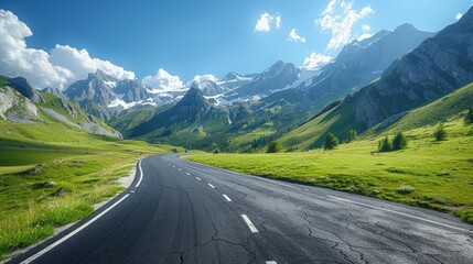 Naklejka premium The winding asphalt road cuts through a majestic mountain range under a clear, brilliant blue sky, offering breathtaking views