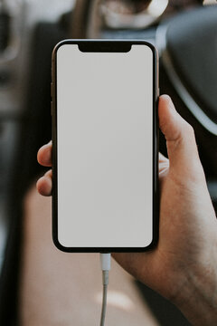 Hand holding a smartphone in a car design element